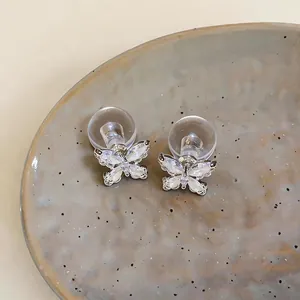 Detailansicht von Schmetterlings-Ohrsteckern mit Zirkonia und klarem Verschluss.