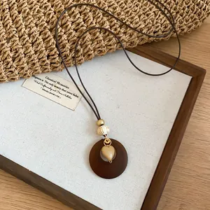 Detailed view of bohemian heart pendant necklace on minimalist display board