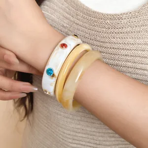 Close-up van vintage hars armbanden met kleurrijke strassteentjes om een pols.