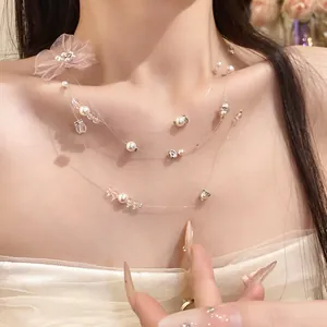 Gros plan d'un collier de perles multicouche avec fleur en mousseline sur le cou d'un mannequin.