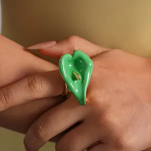 Detalle de un elegante anillo ajustable de flor de cala en esmalte verde en la mano.