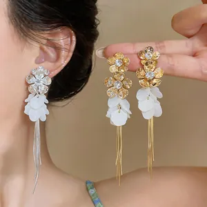 Detailed view of elegant zircon flower earrings with white resin petals and long tassels