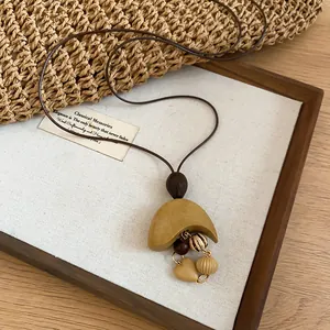 Detailed view of Bohemian vintage necklace featuring wooden heart charms and beaded accents.
