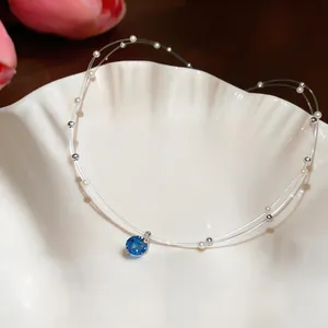 Macro view of blue round zircon pendant with pearls on double-layer choker necklace