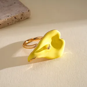 Primer plano detallato de un anillo de flor de cala de esmalte amarillo y dorado