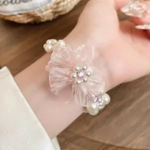 Gros plan d'un bracelet en perles multicouches avec une fleur en mousseline