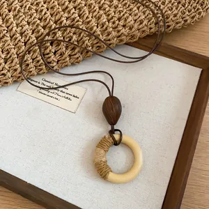 Close-up detail of a bohemian retro circle pendant necklace with straw wrap texture on linen