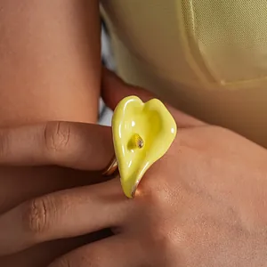 Vista detallada de un anillo abierto de esmalte con forma de cala amarilla y pistilo.