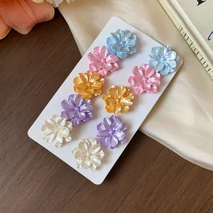 Primer plano de conjunto de pendientes de flores de colores con un acabado perlado