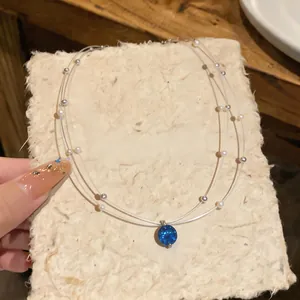 Detailed view of elegant double-layered necklace with blue zircon and pearls