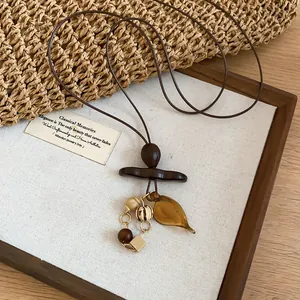 Close-up of Bohemian retro sweater chain with amber leaf pendant and wooden beads