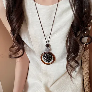 Close-up of Bohemian style circular wood pendant necklace on model with linen top