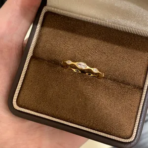 Nahaufnahme eines goldfarbenen Marquise-Zirkonia-Rings in einer braunen Samt-Schmuckschatulle