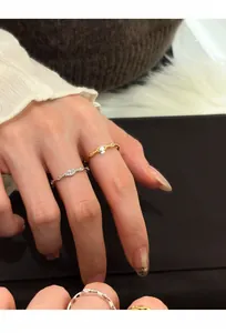 Detailansicht von minimalistischen offenen Ringen mit ovalem Zirkon in Gold und Silber