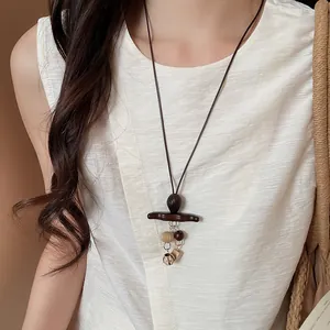 Close-up of a Bohemian style long sweater necklace with wooden and beaded charms