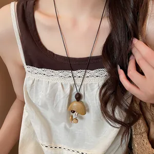 Close-up detail of a bohemian retro style sweater necklace worn by an Asian model