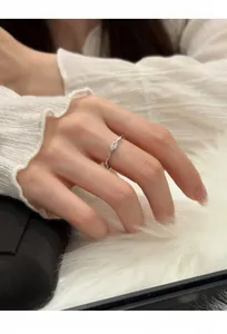 Detailansicht eines Zirkonia-Ovalrings am Finger mit weichem weißem Hintergrund