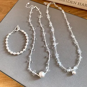 Detailed view of handmade silver beaded bracelet and long clear crystal necklaces set