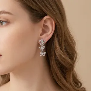 Minimalist silver-plated hollow flower drop earrings worn by a model in a lifestyle shot