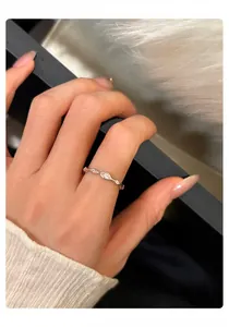 Nahaufnahme eines minimalistischen Silberrings mit Zirkonia-Steinen an einem Finger.