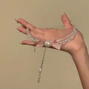 Primo piano dettagliato di una collana di perle con fiocco di strass e nappa di cristallo