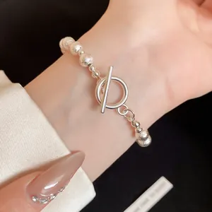 Textured silver beaded bracelet with minimalist T-bar toggle closure on wrist