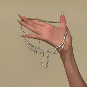Vista a mano della collana con fiocco in strass scintillanti e nappe