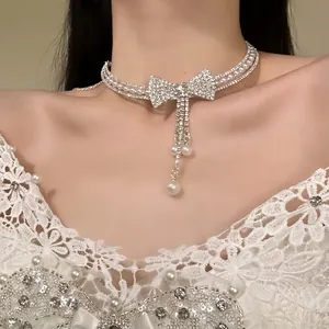 Primo piano di un girocollo di lusso con fiocco di strass ed eleganti nappe di perle.