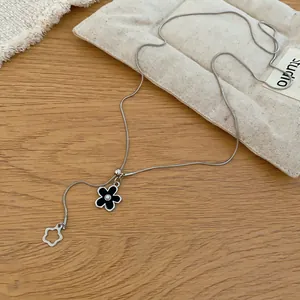 Dettaglio ravvicinato di una collana con ciondolo a fiore di perle e catena a serpente