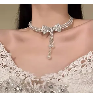 Elegante collana girocollo con fiocco di strass, perle e dettagli nappa in zircone