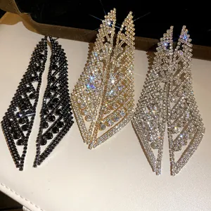 Vue détaillée des boucles d'oreilles feuilles en strass or, argent et noir