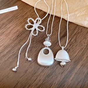 Elegant silver-toned necklaces featuring hollow flower, teardrop, and heart bell pendants.