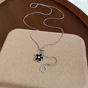 Dettaglio collana a catena a serpente d'argento con fiore smaltato nero e perla