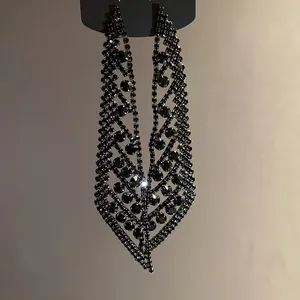 Vue détaillée de boucles d'oreilles élégantes en strass noir en forme de feuille pour soirée