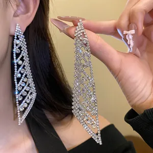 Vue détaillée de boucles d'oreilles à pompons en strass argentés avec un design à franges