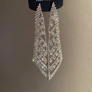 Vue détaillée de boucles d'oreilles en forme de feuille avec strass