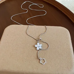 Vista dettagliata di una collana argento con pendente a fiore di perla su blocco