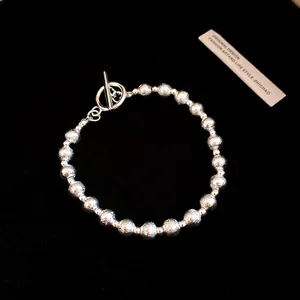 Macro view of textured silver beaded bracelet featuring a stylish toggle clasp closure.