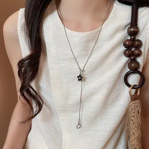 Dettaglio di una collana regolabile in stile coreano con un ciondolo a fiore nero