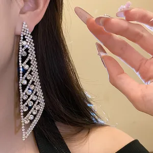 Gros plan sur des boucles d'oreilles à pompons en argent et strass brillants