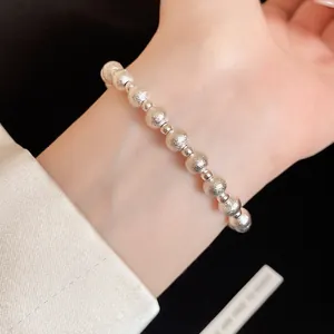 Detail view of silver-toned textured beaded bracelet worn on a feminine wrist elegance.