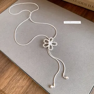 Detail of silver adjustable necklace with hollow zircon flower pendant on grey background