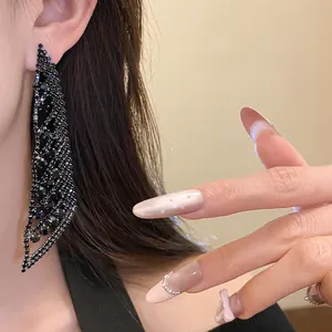 Gros plan élégant de boucles d'oreilles à pampilles en strass noirs sur l'oreille
