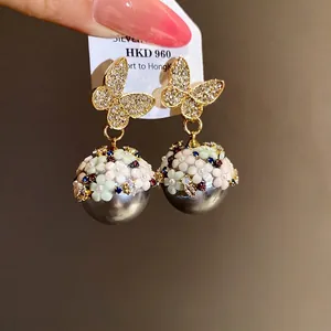 Elegant crystal butterfly drop earrings featuring floral grey pearls and silver needles