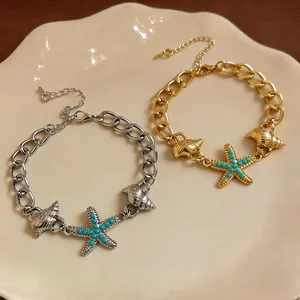 Vista dettagliata di bracciali in argento e oro con ciondoli a stella marina e conchiglia