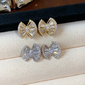 Close-up of elegant 18k gold and silver plated geometric zircon stud earrings on velvet