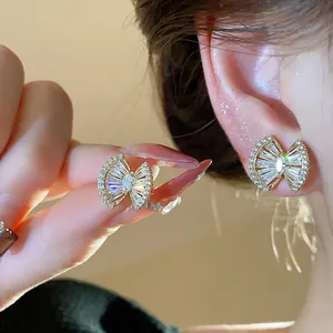 Close-up detail of 18k gold plated geometric stud earrings with sparkling zircon stones