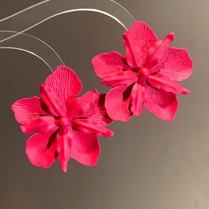 Detailed macro shot of elegant magenta orchid flower stud earrings with matte finish