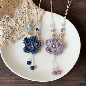 Detail of hand-woven flower necklace with wooden and ceramic beads for a vacation style look