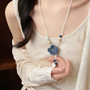 Detail of handcrafted woven blue flower necklace featuring wooden and ceramic beads